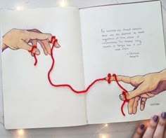 an open book with two hands and string attached to it