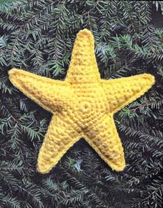 a crocheted yellow starfish is hanging on a green christmas ornament