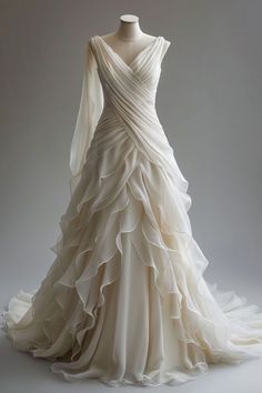 a white wedding dress with ruffles on the skirt