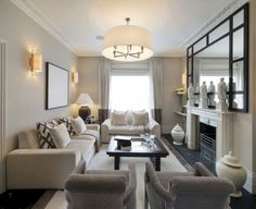 a living room filled with furniture and a fire place in front of a mirror on the wall