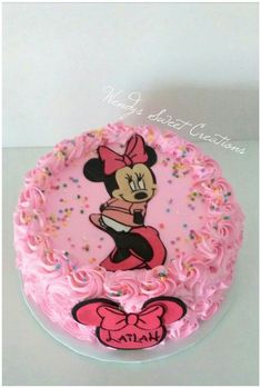 a minnie mouse cake with pink frosting and sprinkles