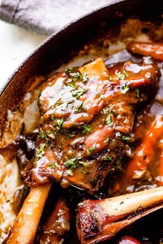 a pot filled with meat and vegetables covered in gravy