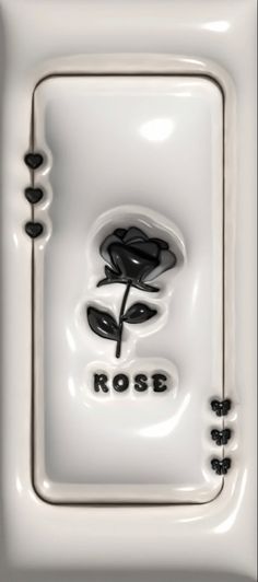 a white square object with a rose on it's side and the word rose written in black