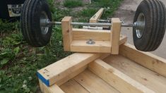 a bench made out of wooden planks with wheels attached to it