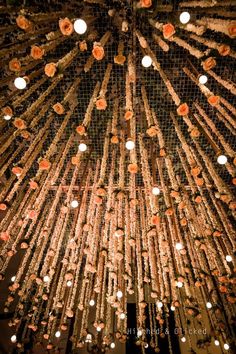 a large chandelier with flowers hanging from it's sides and lights on the ceiling