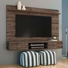 an entertainment center with two stools and a flat screen tv mounted on the wall