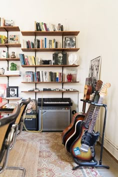 a room with guitars and bookshelves in it