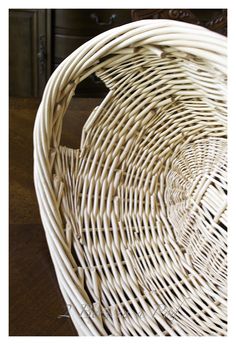 a white wicker basket sitting on top of a wooden table next to a drawer