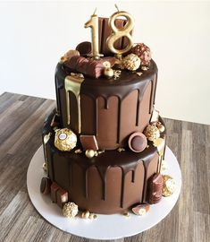 a chocolate cake with gold decorations and the number eight on top is sitting on a white plate