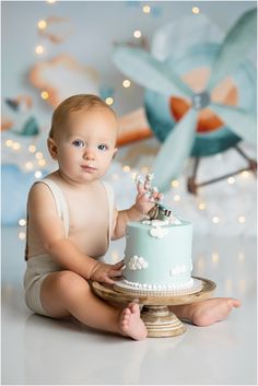 a baby sitting on the floor with a cake