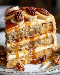 a piece of cake on a plate with pecans around it and caramel sauce