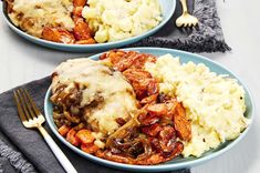 two plates filled with meat and potatoes covered in gravy