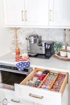 an open drawer in a kitchen filled with condiments and other items on the counter