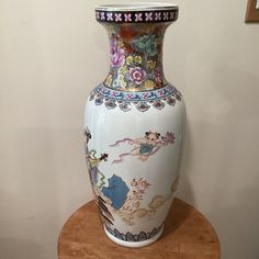 a white vase sitting on top of a wooden table