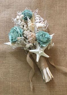 a bridal bouquet with seashells, starfish and flowers on a burlap background