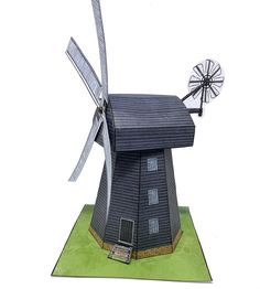 a paper model of a windmill on top of a green field