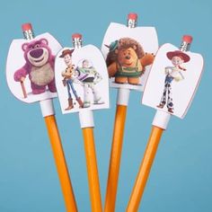 three pencils with pictures of cartoon characters on them are in a cupcake holder