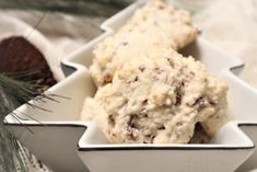 two white bowls filled with ice cream next to pine cones