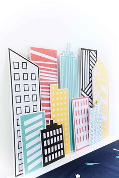 an art piece made out of paper with cityscape on the wall behind it