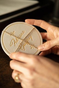 a person is holding a white and gold cookie