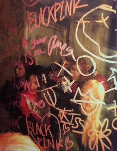 a group of young people standing in front of a chalkboard with writing on it