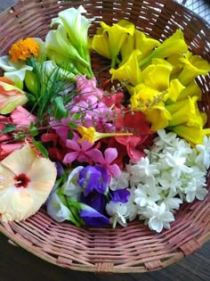 a basket filled with lots of different colored flowers