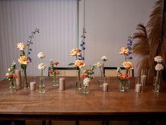 there are many vases with flowers on the table