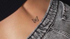 a woman with a small butterfly tattoo on her chest