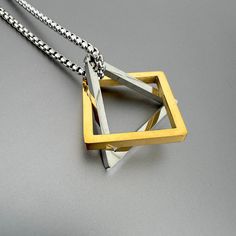 Interlocking triangle and square pendant on silver stainless steel chain. Use triangle and square interlocking pendants together or individually.  Chain length 24 inches High-grade stainless steel. CARE: Stainless Steel:  Use a polishing cloth to gently wipe this item clean, then remove any remaining tarnish with mildly diluted soap. Rinse with warm water and dry thoroughly.  STORAGE: When not in use, store your item in the provided jewelry pouch. We gladly accept returns and exchanges if the it Modern Stainless Steel Square Pendant Necklace, Ancient Egyptian Jewelry, Square Pendant Necklace, Triangle Square, Egyptian Jewelry, Square Pendant, Steel Chain, Jewelry Pouch, Stainless Steel Chain