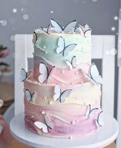 there is a multi layer cake with butterflies on the frosting and pink icing