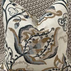 a close up of a decorative pillow on a couch with a brown and blue pattern