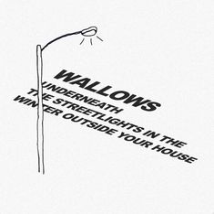 a black and white poster with the words walows underneath it, in front of a light pole