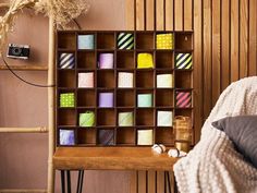 a wooden shelf with many different colored sticky notes on it