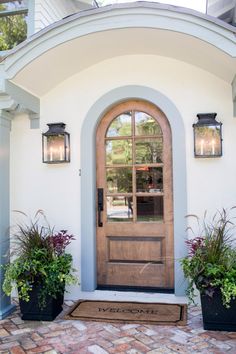 a front door with two planters on either side