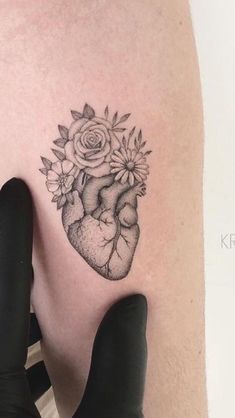 a woman's arm with a tattoo on it that has a heart and flowers