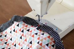 the sewing machine is using fabric to sew on it's sides, which are dotted with black and white polka dots