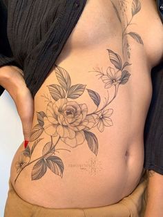 a woman with a flower tattoo on her stomach