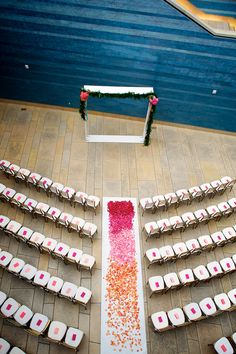 an aerial view of a wedding ceremony with white chairs and pink confetti on the aisle