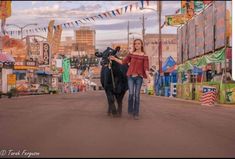 a woman walking down the street with a cow