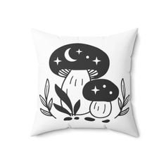 a black and white pillow with an image of two mushrooms in the woods on it