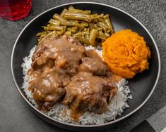 a plate with meat, rice and green beans