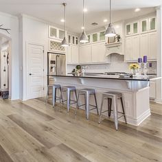 a kitchen with white cabinets and wooden floors