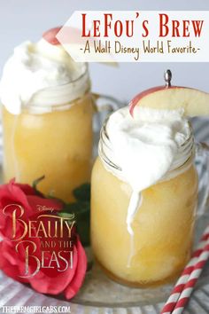 two mason jars with whipped cream and an apple slice on top, sitting next to each other