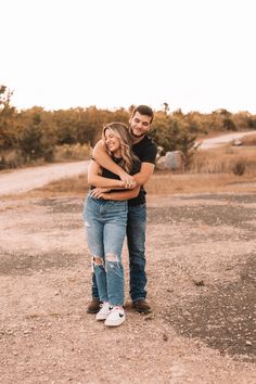 a man and woman hugging each other in the dirt