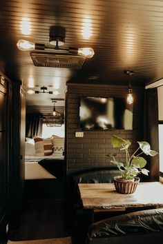 a living area with couches, table and television in the back room at night