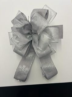 a large silver bow on top of a white table