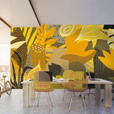 a dining room with yellow chairs and an artistic wall mural behind the dinning table