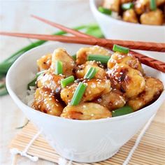 two white bowls filled with food and chopsticks