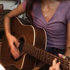 a woman is playing an acoustic guitar in her living room