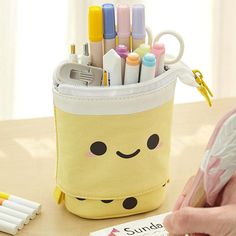 This convertible pencil pouch goes to the next level! Enjoy the cute faces on the front and the fun bubble tea at the bottom while you carry your pens, pencils, scissors, cosmetics, or other accessories. It can be comfortably carried around and also transformed into a convenient pen stand on your desk. It has 3 compartments inside for quick access. To transform the pencil case, set it on your desk, open the zipper, and pull down on the two side tabs. The pouch can also be carried with the top sl Pop Up Pencil Case, Cute Boba, Boba Milk Tea, Boba Milk, Pen Stand, Kids Canvas, Pen Pouch, Kawaii Stationery, Pens Pencils